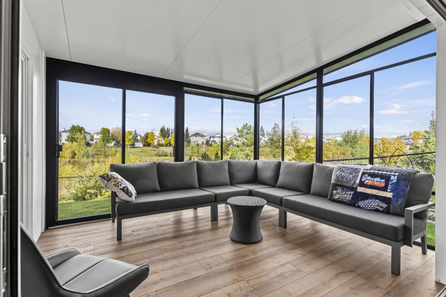 Home remodel adds sunroom with floor-to-ceiling windows and seating.