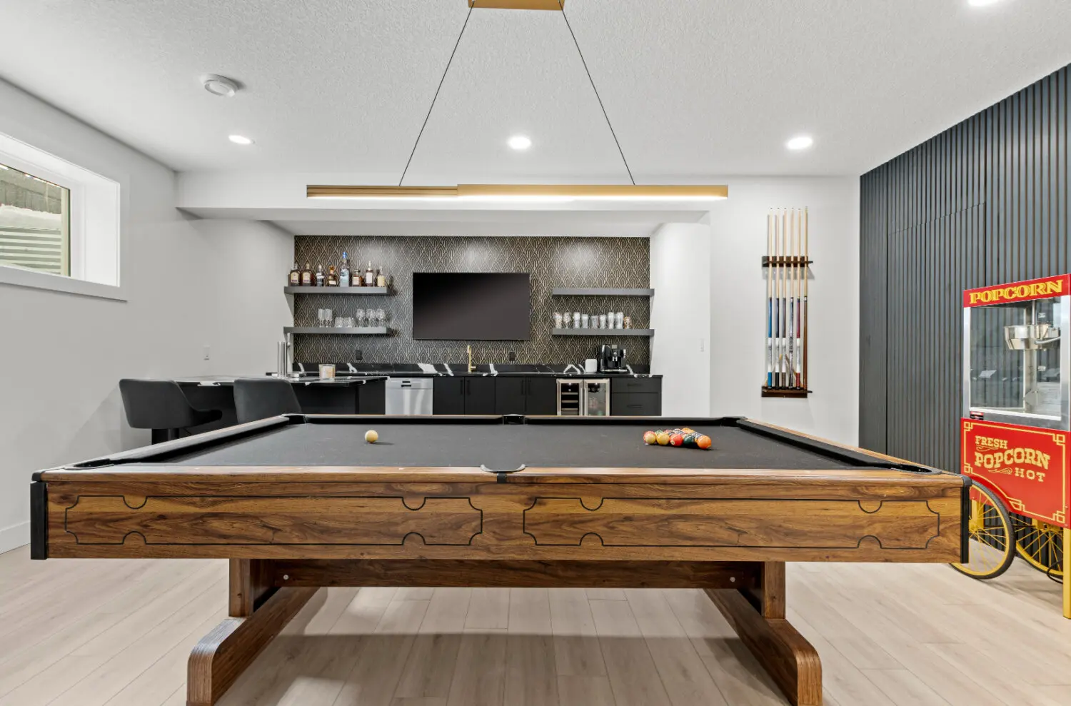Basement renovation features pool table and custom wet bar.