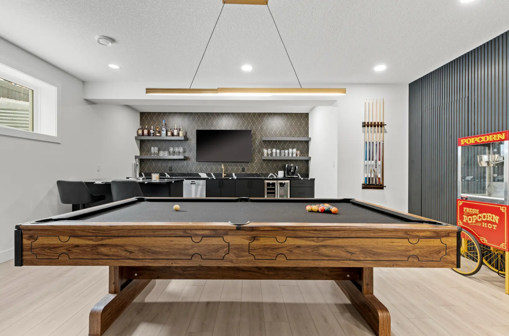 Basement renovation features pool table and custom wet bar.