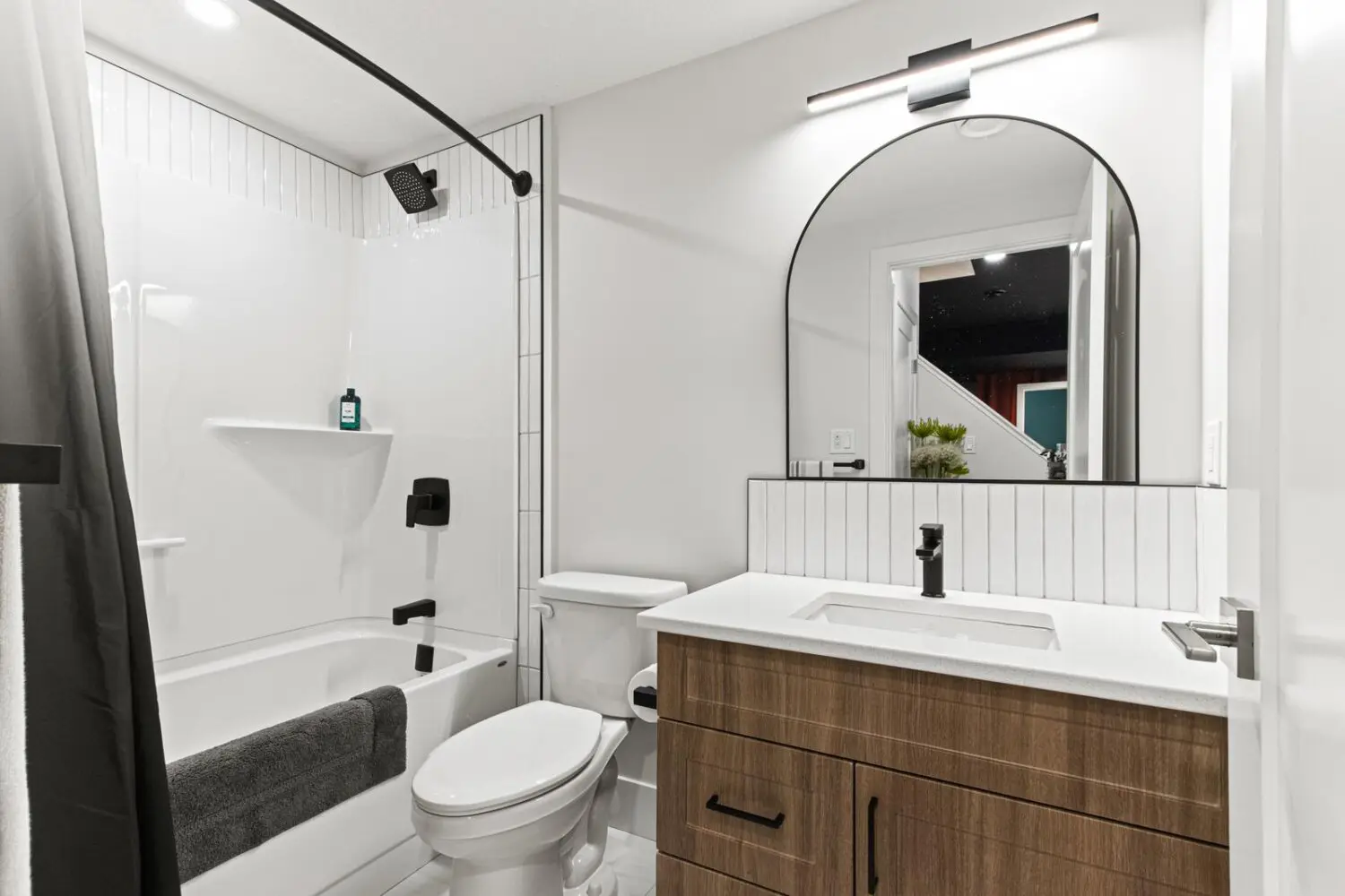 Modern Bathroom with Wood Vanity and Arched Mirror